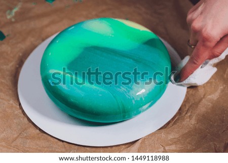 Modern French mousse cake with green mirror glaze. Picture for a menu or a confectionery catalog.
