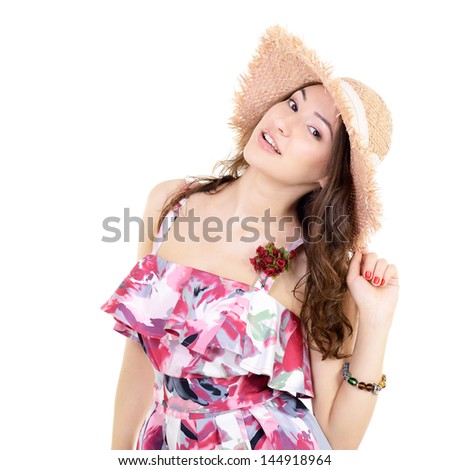 Beautiful cheerful young woman in summer sarafan and straw hat over a white background