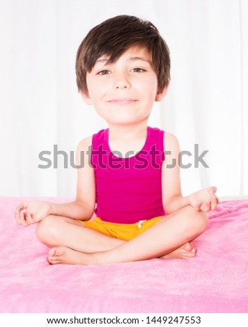 young boy with big head sitting in bed and smiling