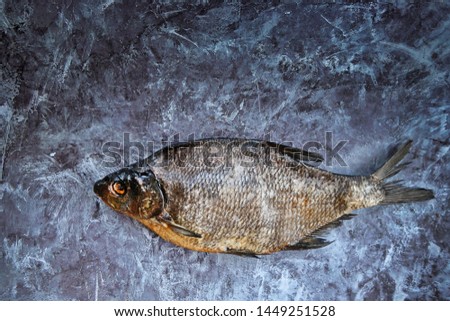 Close-up dried bream on the blue background. Salty dry river fish. Top view. Copy space.
