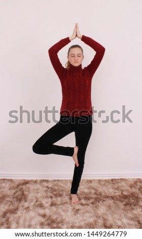 A young woman does yoga exercise in the carpet living room. Healthy lifestyle to relax.
