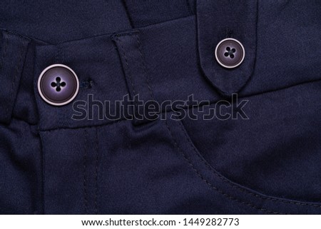 Full frame navy blue trousers extreme close up detail, textile industry background. Flat lay elegant pants abstract wallpaper with copy space. Well dressed, elegant clothes fashion concept backgrounds