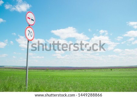 horizon with green grass in a field with blue sky and clouds and road sign