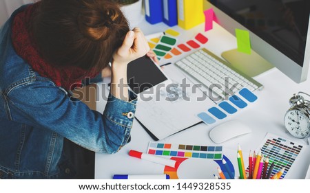 young woman artist drawing something on graphic tablet at the office