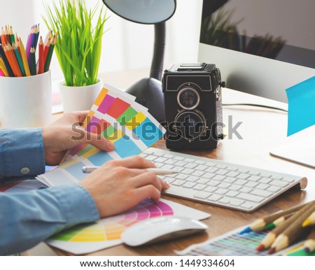 Young cute Graphic designer using graphics tablet to do his work at desk
