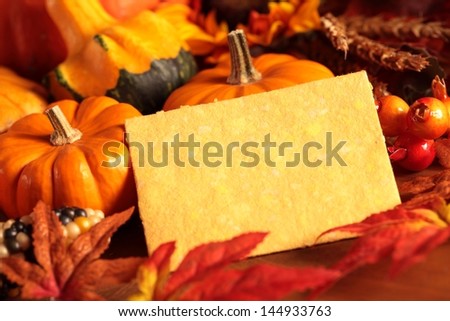 Arangement of pumpkins and autumn decorations on wooden background with paper copy space.