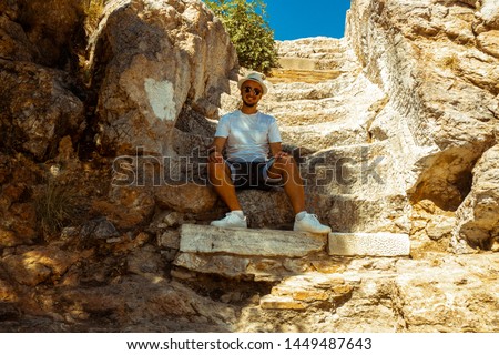 man sits at the ancient greek ruins