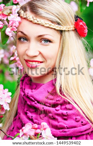 young beautiful girl with flowers in her hair in the park in spring