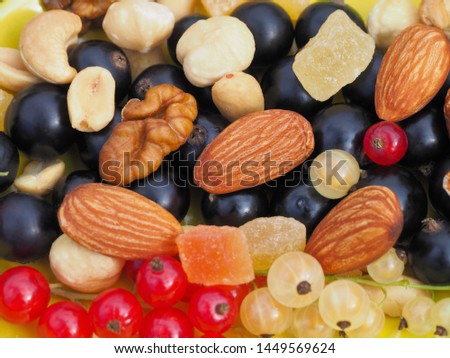Different beautiful nuts, candied fruits and fresh berries of red, white, black currant close-up. Clean and appetizing picture of dessert for decoration Wallpaper