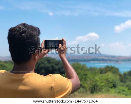 A young man clicking the panoramic picture of the sea at Instanbul in Turkey. 