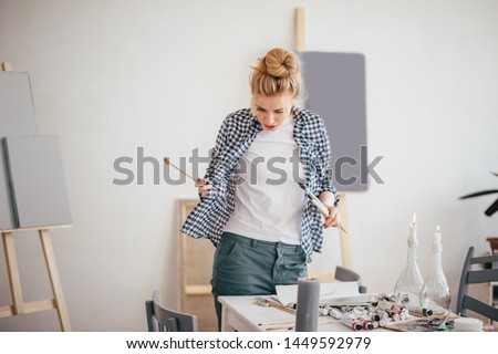 blond artist has lost her tool for painting, frustrated artist dirties her clothes while painting