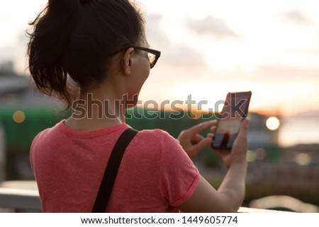 Woman use smartphone in sunset Hong Kong