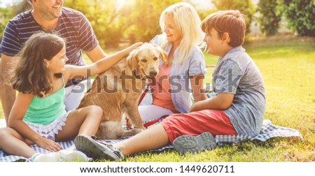 Happy family doing picnic in nature outdoor - Young parents having fun with children and their dog in summer time laughing together - Positive mood concept - Focus on mother, father faces