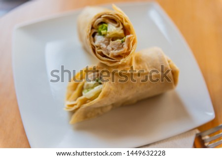 Chicken breast with caesar dressing and lettuce in a gluten-free tortilla wrap, tasty food