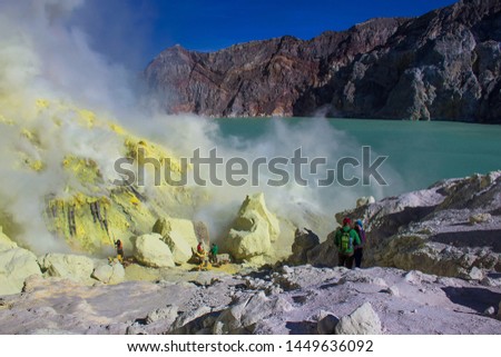 Sulfuric acid lake and gas coming out of the sulphur mines in the crater on the bottom of Mount Ijen active volcano, Banyuwangi, East Java, Indonesia.  Royalty-Free Stock Photo #1449636092
