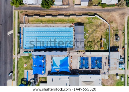 Aquatic centre with hot springs baths and swimming pool in Moree town of Narrabri shire, Australia - overhead aerial top down view. Royalty-Free Stock Photo #1449655520