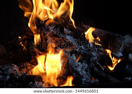 Trash and Paper are burning in the fire on black background
