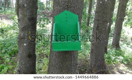 nesting box hanging on a tree in the daytime
