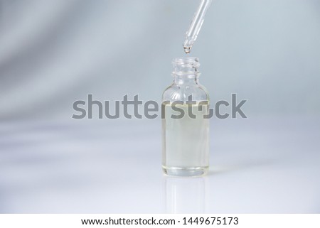 Dropper glass bottle with pipette. Mock up Essential liquid . On a blue background