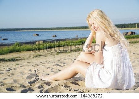 Woman in white dress indulgence on warm beach