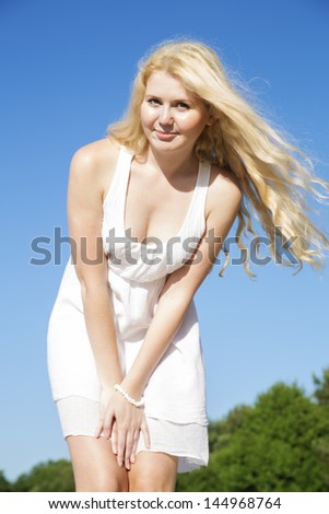Posing woman in white dress with soft hairs