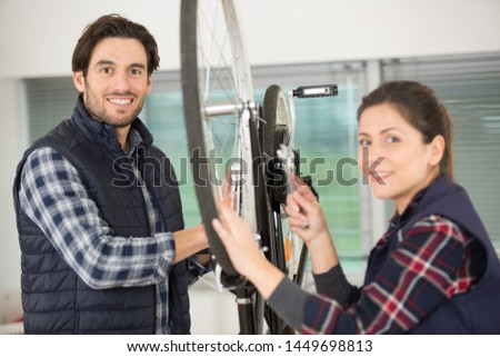 male and female mechanics working on a bicycle