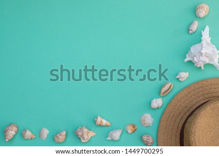 Hat and shells on a turquoise background, summer mood, empty space for text