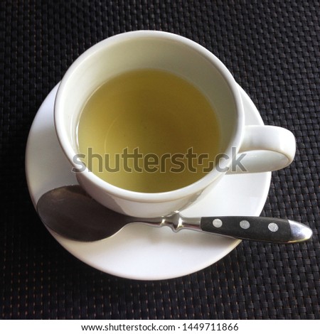 Macro photo cup of green tea. Background white cup with tea on a saucer. Image top view cup of green tea in a cafe