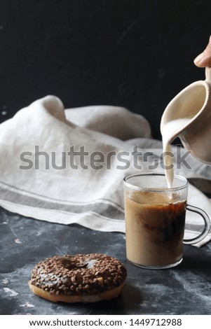 Chocolate donut and coffee on a black background
