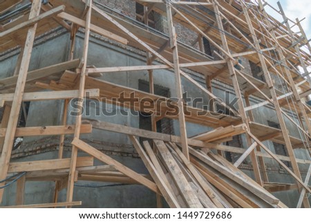 Home construction. Wooden scaffolding on a building close up