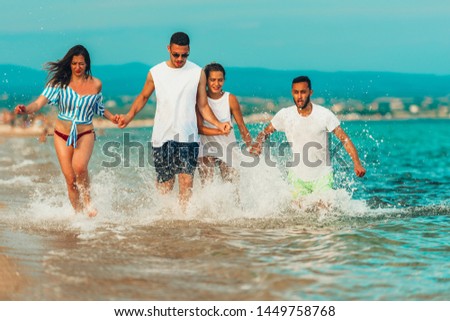 Group of active people dancing and having fun on the beach on vacation