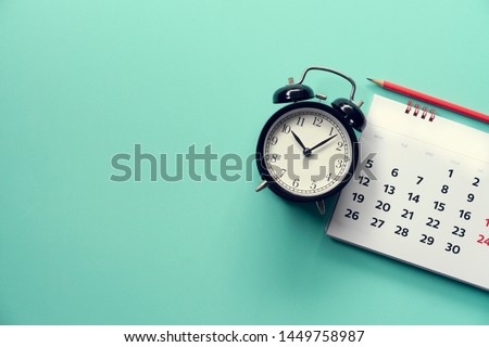 close up of calendar and alarm clock on the green background, planning for business meeting or travel planning concept