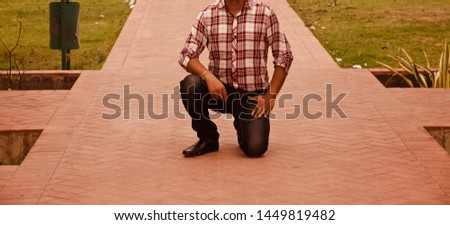 Man wearing black jeans sitting on his knees unique photo