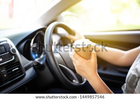 Abstract Blur picture, Hand holding hot coffee take away cup on car 