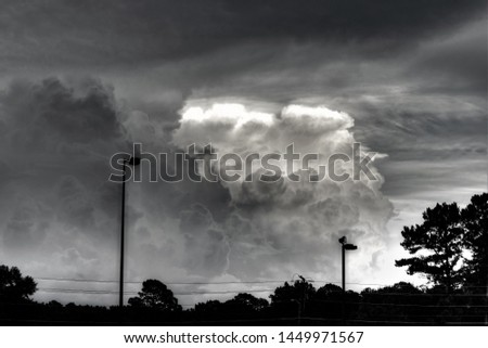 Storm clouds rising into cirrus overcast, black and white, stormy suburb sky.