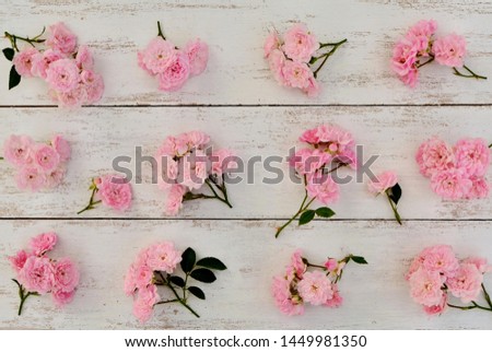 White wooden background with small pink roses