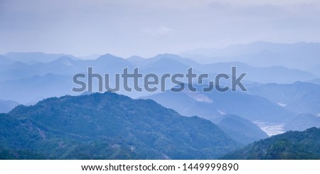 Rolling mountains in Hongu area on the Kumano Kodo trail. Kumano Kodo is a series of ancient pilgrimage routes that crisscross the Kii Hanto, the largest  peninsula of Japan Royalty-Free Stock Photo #1449999890