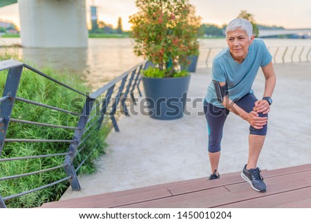 Elderly women accident from exercise. knee ache. Sport woman runner hurting holding painful sprained ankle pain. Woman holding her painful knee after exercising in park