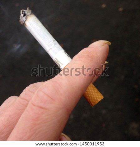 Macro photo of cigarette in hand. Background smoking cigarette in hand. Image of smoking a cigarette