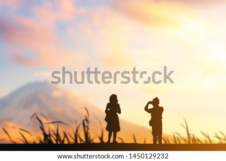 Silhouette of man taking photo of his girlfriend evening blurred sunset background, Happy and enjoy travel concept