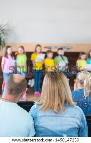 Performance by talented children. Children on stage perform in front of parents. image of blur kid 's show on stage at school , for background usage. vertical photo. Blurry