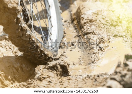 the Bicycle wheel is stuck in the mud. Close up