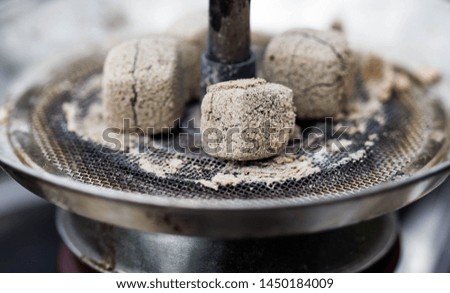 Hookah coals in a steel Cup. Smoldering coal in a hookah close-up. Smoke hookah.