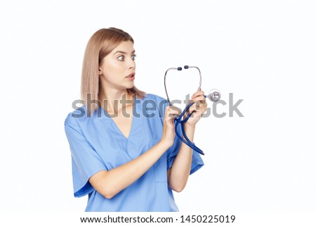 A female doctor is examined with a stethoscope in her hands and a blue robe