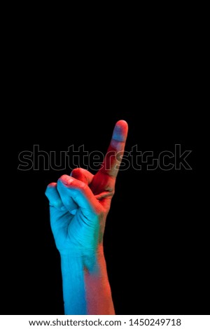 Bright fluorescent colorful hands isolated on a dark background. Close-up.
