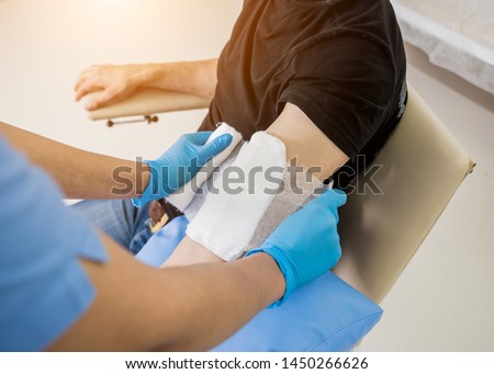 Nurse dressing wound for patient's hand with burn injury. Medical background Royalty-Free Stock Photo #1450266626