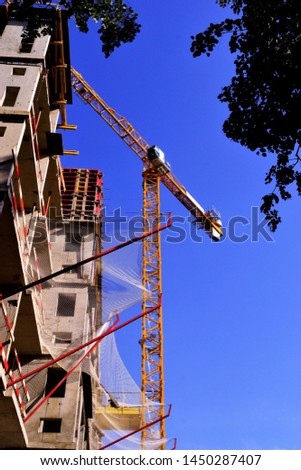 Construction of a high-rise comfortable residential building with a tower crane. Construction of structures-architectural, organizational, survey, design, installation, commissioning of the object.  Royalty-Free Stock Photo #1450287407
