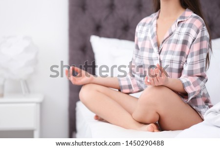 Young woman meditating on bed at home, closeup. Zen concept