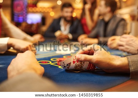 People play poker at the table in the casino. Royalty-Free Stock Photo #1450319855