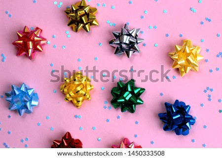 texture of a lot of festive bows in the form of a star on a pink background